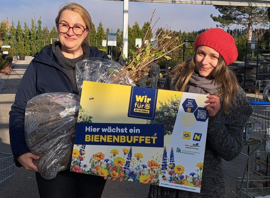 zwei Frauen halten ein Schild
